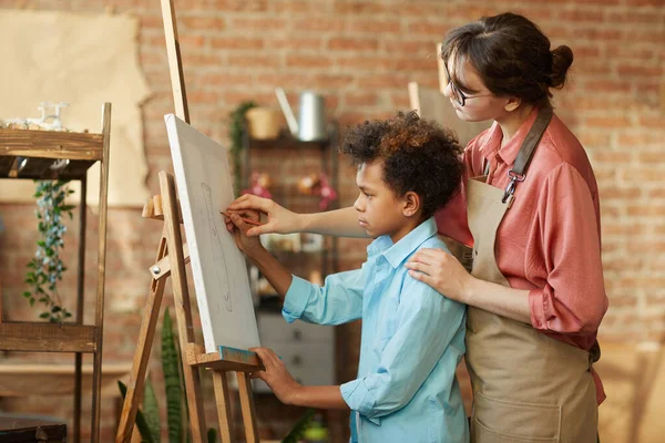 Profesor enseñando niño a pintar — Foto de Stock