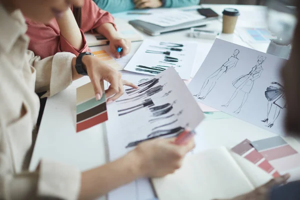 Designers examining fashion sketches