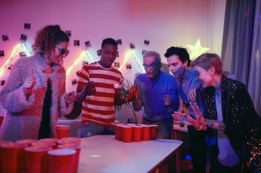 Senior man playing in beer pong game