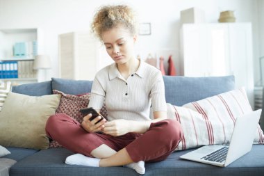 Evde cep telefonu kullanan bir kadın