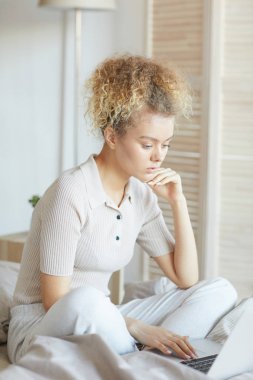 Yatakta dizüstü bilgisayar kullanan kadın