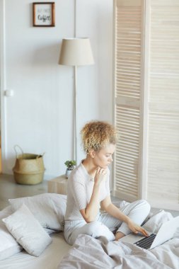 Woman working online in the bedroom
