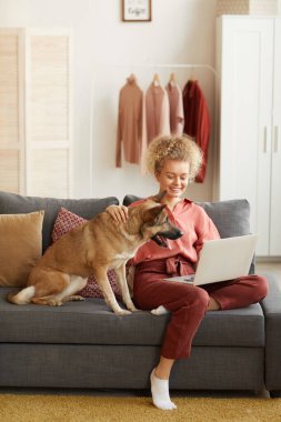 Köpeğiyle evde çalışan bir kadın.