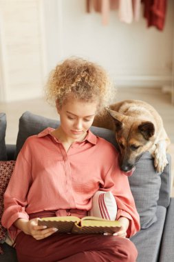 Evde kitap okuyan bir kadın.