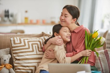 Anne ve kızı birbirlerine sarılıyorlar.
