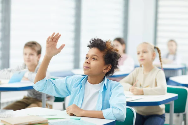 Estudante levantando a mão na classe — Fotografia de Stock