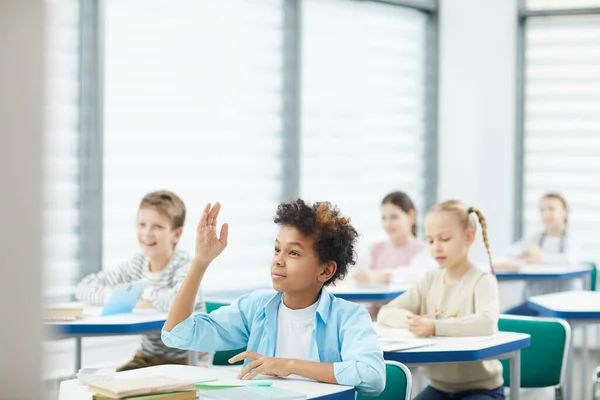 Афроамериканський хлопчик піднімає руку в класі — стокове фото