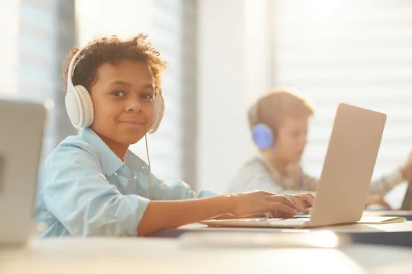 Niño en auriculares en la escuela — Foto de Stock