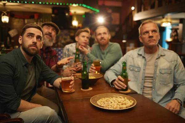 Grupo de amigos bebiendo cerveza en el bar deportivo —  Fotos de Stock