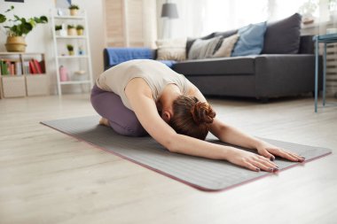 Evde rahatlama egzersizi yapan bir kadın.