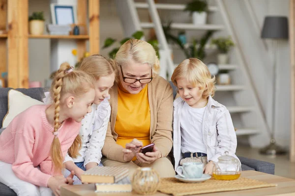 Nietos ayudando a usar el teléfono a la abuela — Foto de Stock