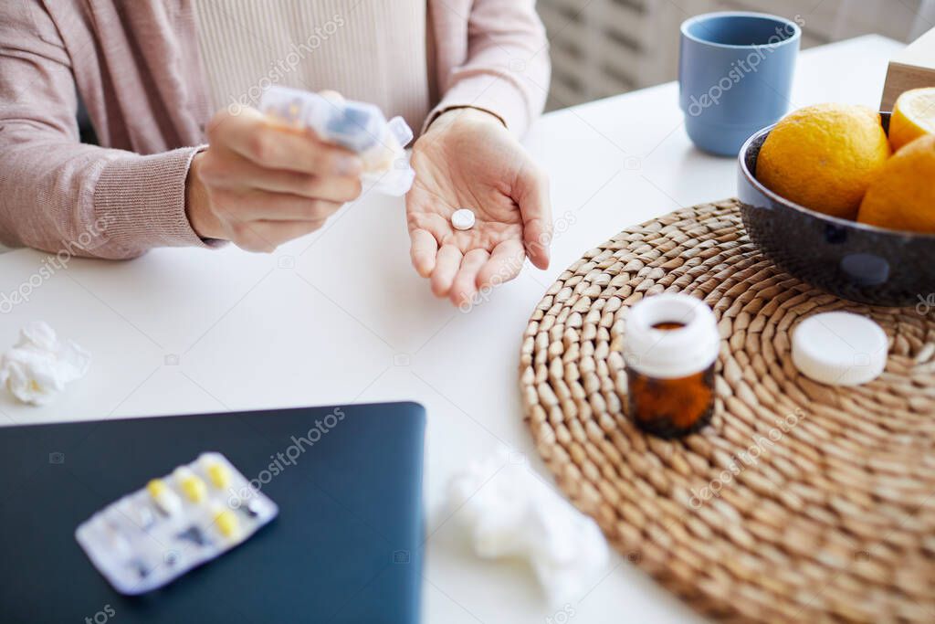 Woman drinking pills from temperature