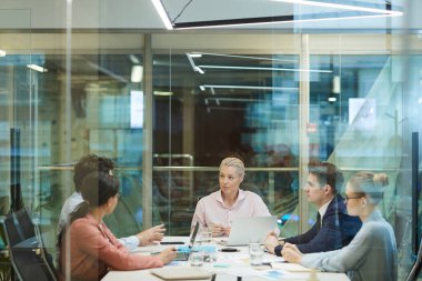 Cam duvarın arkasında iş toplantısı.