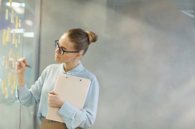 İş kadını ofiste notlar alıyor