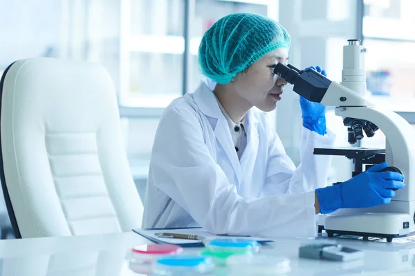 Mujer que trabaja con microscopio en el laboratorio — Foto de Stock