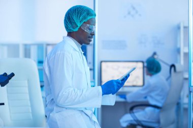 Çalışırken tablet kullanan Afrikalı doktor