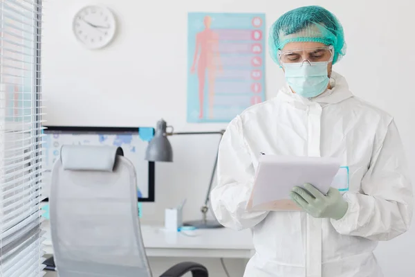 Médico masculino preenchendo o cartão médico — Fotografia de Stock