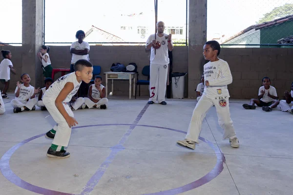 Rio de Janeiro, Brezilya - 9 Ağustos 2016: Brezilya capoeira sınıfındaki çocuklar ve arka planda berimbau enstrümanı çalan bir öğretmen kenar mahallelerdeki bir spor salonunda