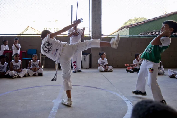 Rio de Janeiro, Brezilya - 9 Ağustos 2016: Brezilya capoeira sınıfındaki çocuklar ve arka planda berimbau enstrümanı çalan bir öğretmen kenar mahallelerdeki bir spor salonunda