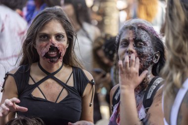 Rio de Janeiro, Brezilya - 2 Kasım 2019: Ölüm Günü 'nde zombi yürüyüşünde yaralanan iki genç kız, Finados, Copacabana' da kameraya gülümseyen bir kalabalığın arasında