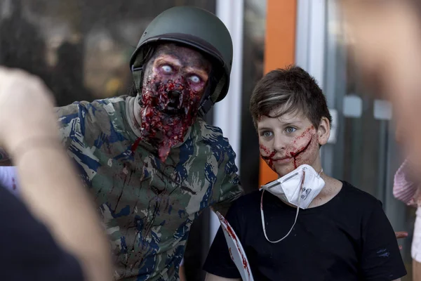 Rio de Janeiro, Brezilya - 2 Kasım 2019: Yetişkin ve çocuk, Copacabana 'da bir asker ve genç bir sivil zombiyle Cadılar Bayramı yürüyüşlerinde poz verdiler