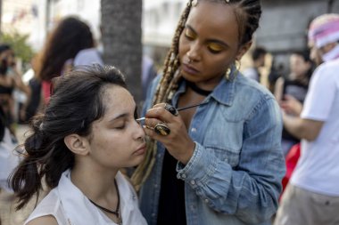 Rio de Janeiro, Brezilya - 2 Kasım 2019: Copacabana 'da Cadılar Bayramı zombi yürüyüşünden önce genç bir kıza makyaj sanatçısı uygulaması