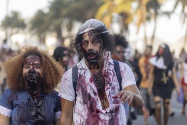 Rio de Janeiro, Brezilya - 2 Kasım 2019: Ölüler Günü 'nde Cadılar Bayramı yürüyüşü, Finados, Copacabana bulvarında ağır yaralı bir çift ve arka planda palmiye ağaçları ile