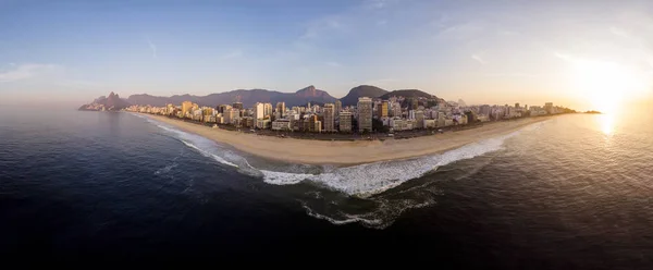 Beautiful summer sunrise in the marvellous city of Rio de Janeiro with waves arriving on the early morning empty beaches of Ipanema and Leblon