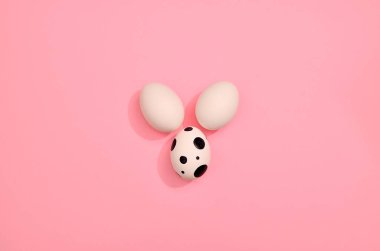 Pembe pastel renkte beyaz yumurta deseni. Pembe arka planda boyanmış yumurtalar. Paskalya tatili konsepti, el yapımı yumurtalar.