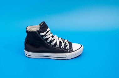 Mavi arka planda duran bir çift mavi spor ayakkabı. Üst Manzara. Flatlay. Telif uzayı merkezi. Metin için boşluk