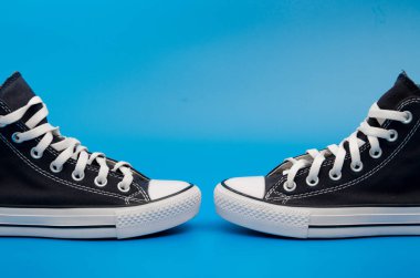 Mavi arka planda duran bir çift mavi spor ayakkabı. Üst Manzara. Flatlay. Telif uzayı merkezi. Metin için boşluk