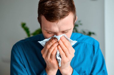 Genç bir işadamının iş yerindeki bir mendille burnunu silmesi. Gerçek problem, soğuk ve soğuk, tıbbi tasarım için arka plan