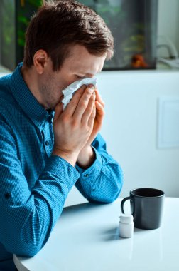 Genç bir işadamının iş yerindeki bir mendille burnunu silmesi. Gerçek problem, soğuk ve soğuk, tıbbi tasarım için arka plan