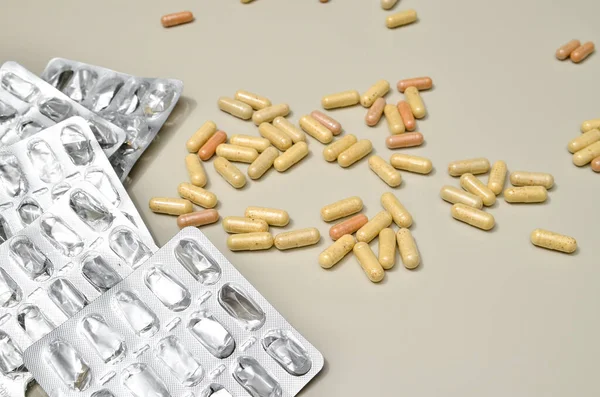 Асорті фармацевтичних препаратів таблетки, таблетки і капсули на бежевому фоні — стокове фото