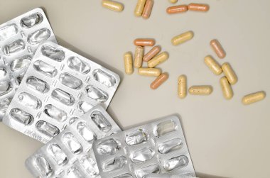 Çeşitli ilaç hapları, tabletler ve kapsüller bej arka plan üzerinde