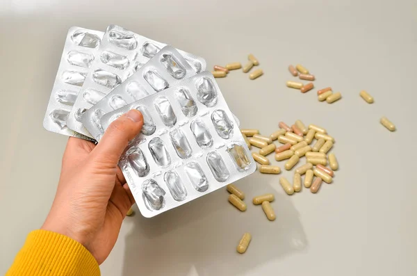 Hands with pharmaceuticals antibiotics pills medicine. colorful antibacterials pills on beige background. capsule pill medicine. Simbol of 2020 year, cronavirus broblem