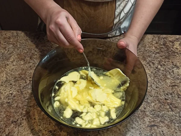Konditor mischt Wasser mit Butter in Schüssel — Stockfoto