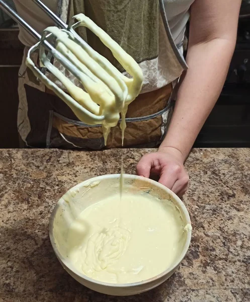Жінка тримає мікшер над мискою з вершками для торта — стокове фото