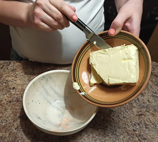 Konditor schüttet Butter von Teller zu Teller — Stockfoto