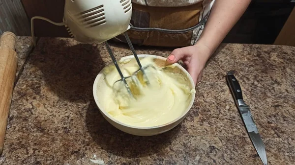 Vrouw mengen crème in kom met mixer voor taart — Stockfoto