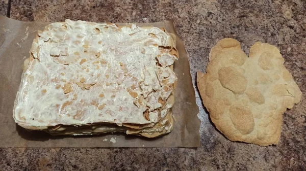 Torta al forno su foglio e strato di torta sul tavolo — Foto Stock