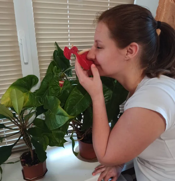 Femme européenne reniflant plante de fleur à la maison — Photo