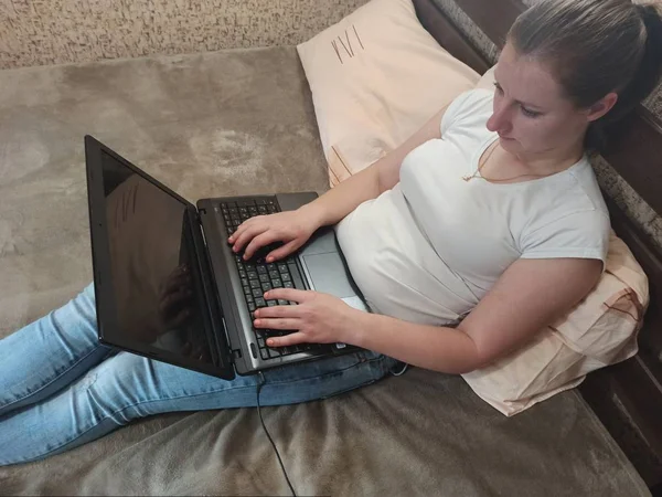 Ευρωπαϊκή γυναίκα που χρησιμοποιεί φορητό υπολογιστή στο κρεβάτι — Φωτογραφία Αρχείου