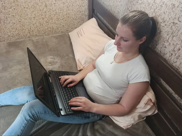 Ευρωπαϊκή γυναίκα που χρησιμοποιεί φορητό υπολογιστή στο κρεβάτι — Φωτογραφία Αρχείου