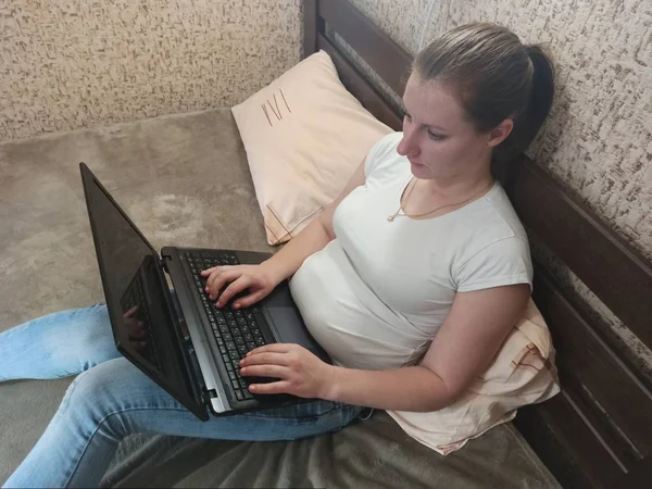 Mujer europea usando portátil en la cama — Foto de Stock