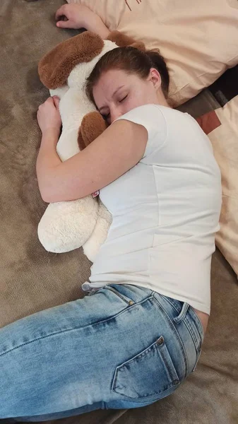 Γυναίκα κοιμάται στο κρεβάτι και αγκαλιάζει το αρκουδάκι — Φωτογραφία Αρχείου