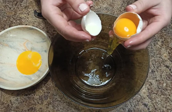 Woman confectioner breaks egg in bowl — Stock Photo, Image