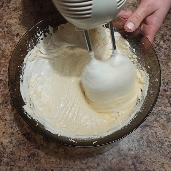 Mulher misturando biscoito para bolo na tigela com misturador — Fotografia de Stock