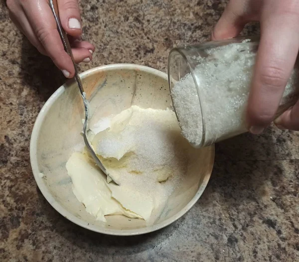 Femme verser le sucre dans un bol avec de la crème sure — Photo