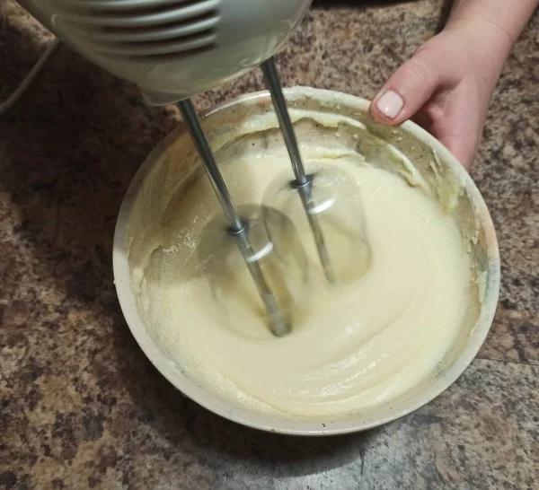 女人把奶油和搅拌器混在碗里 — 图库照片
